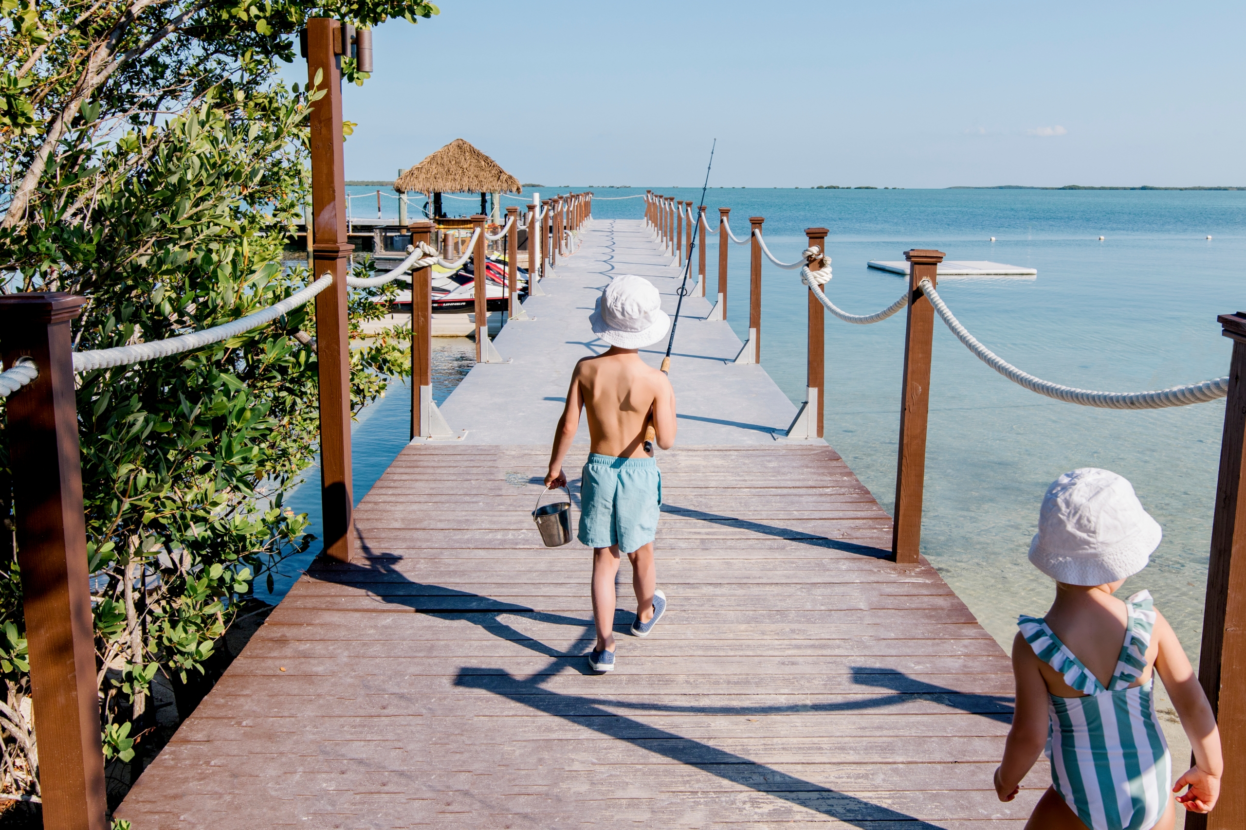 two children walking on a boardwalk