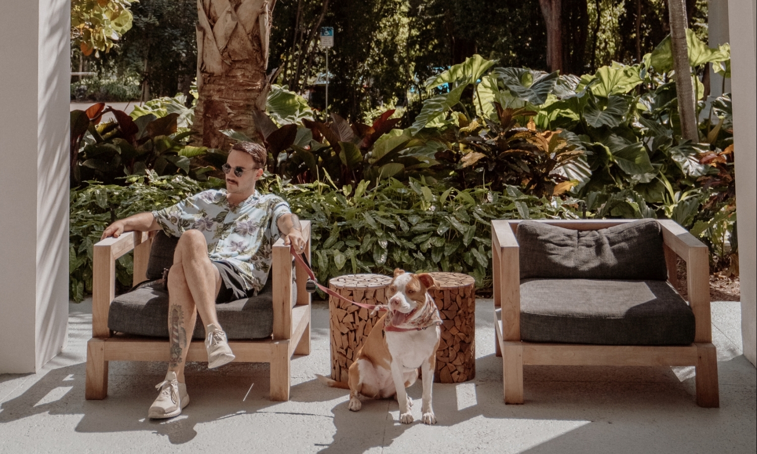 a man sitting outside a resort holding a dog