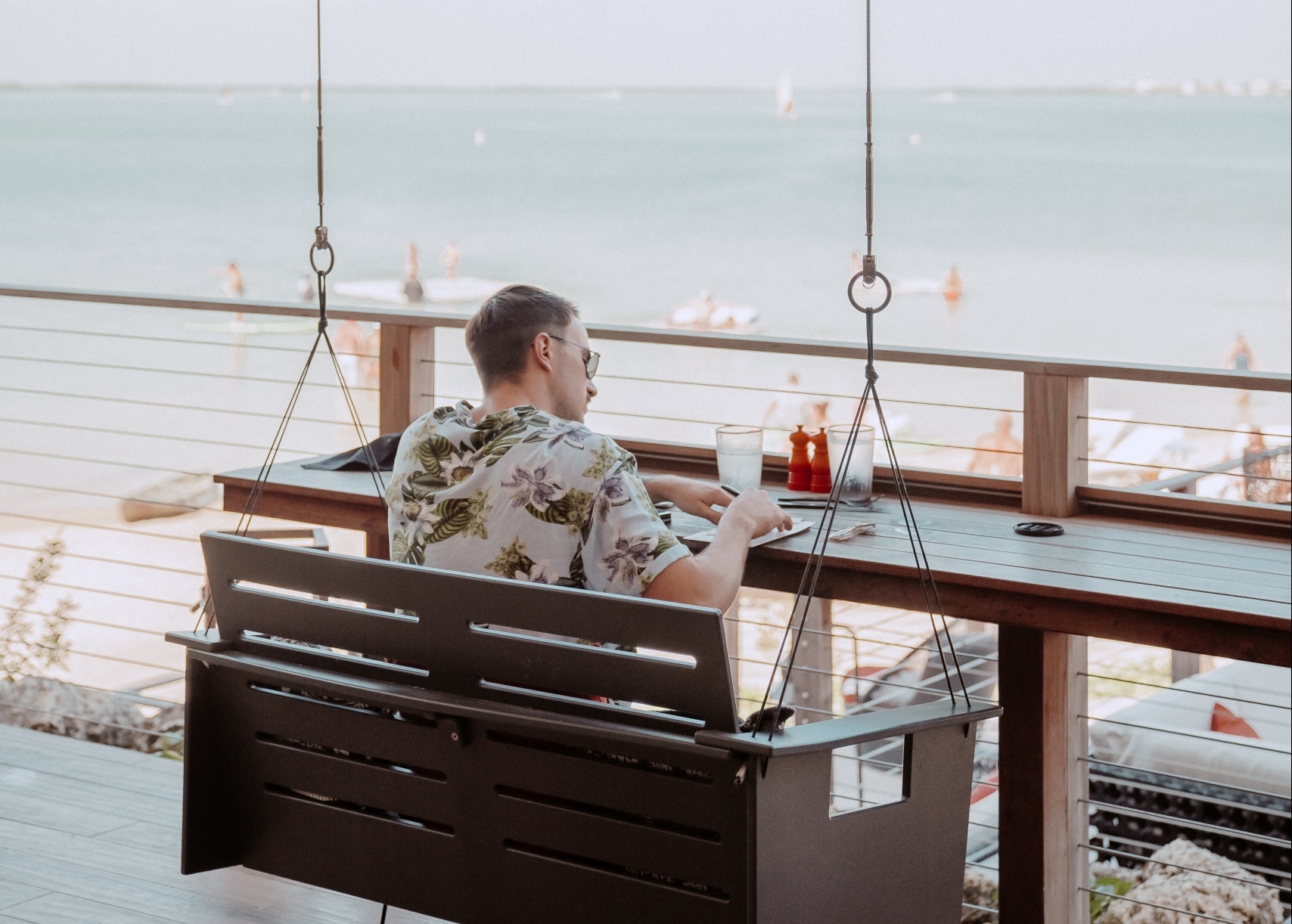 a man sitting outside writing on a pad