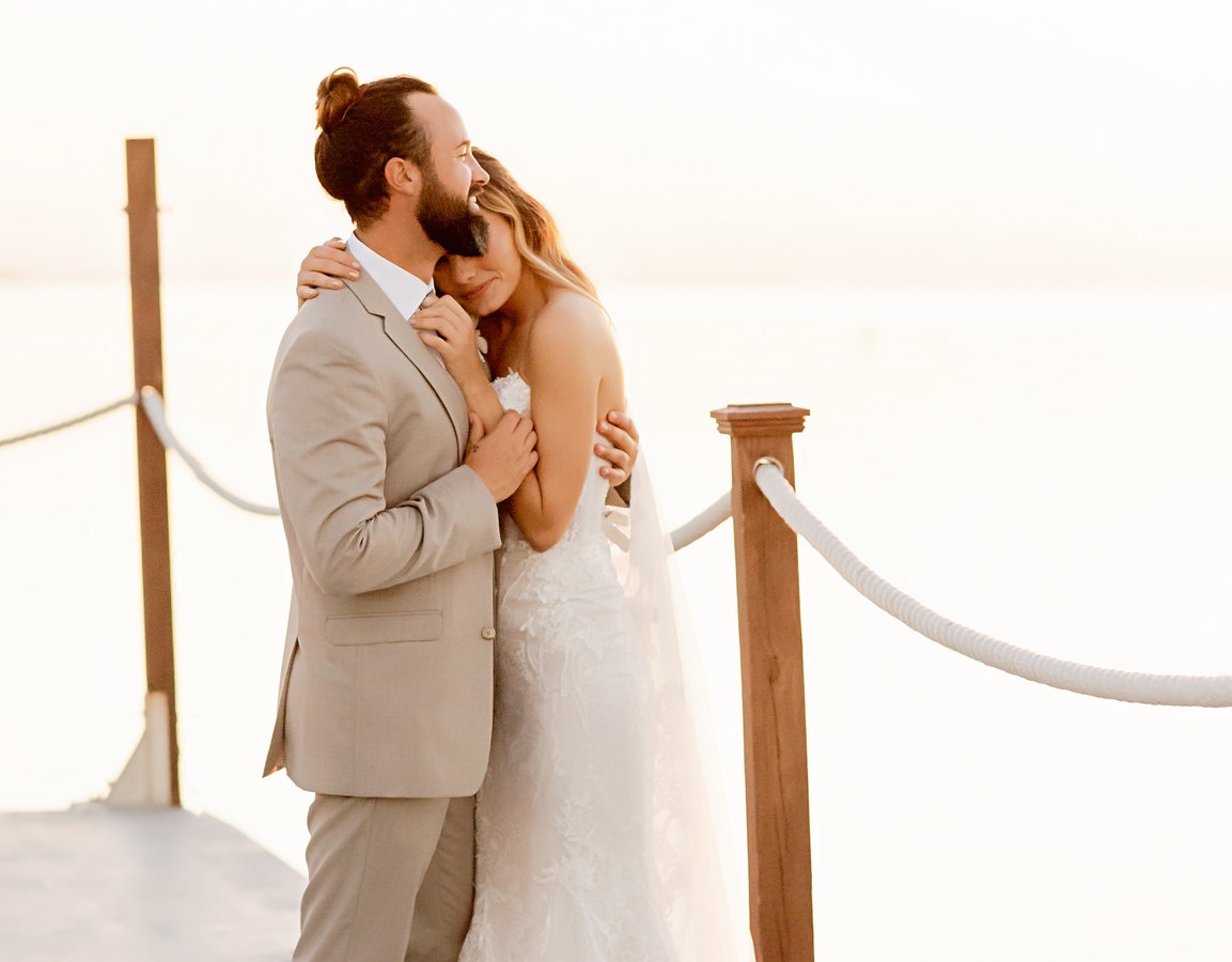 a couple in an intimate embrace with wedding outfits