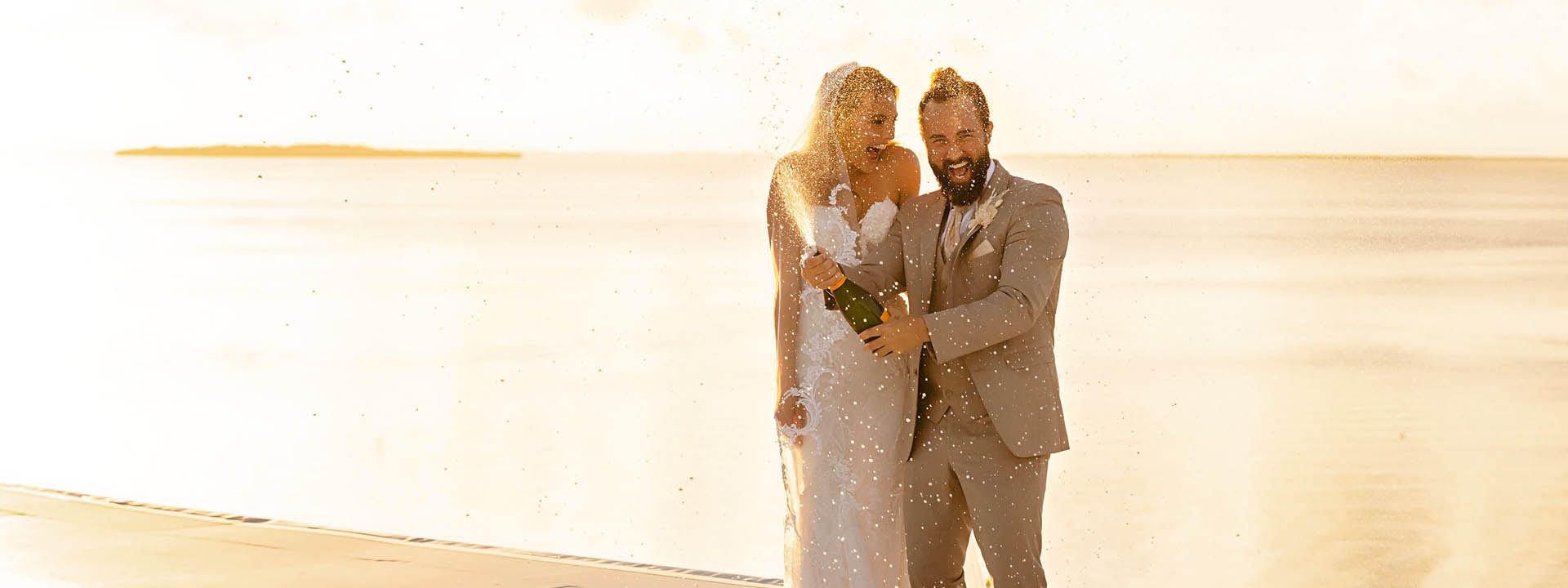 a bride and groom popping champagne