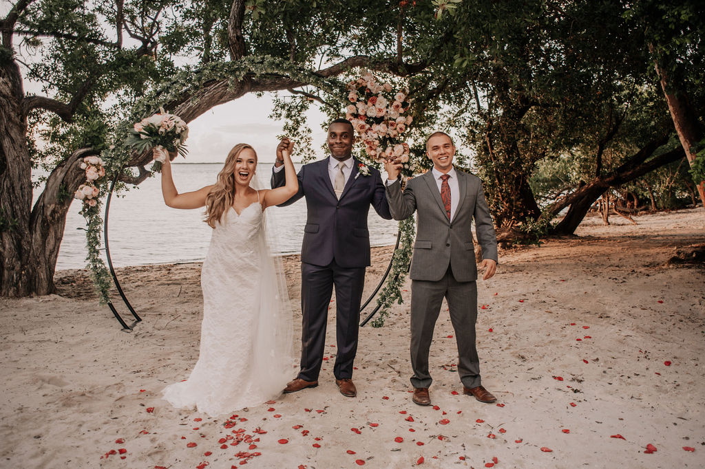 A bride, a groom and a third man in a suit