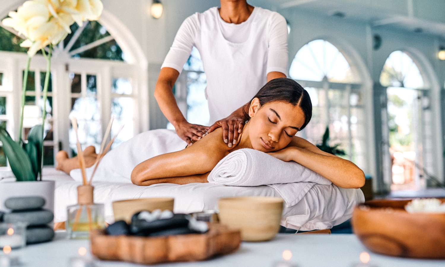 Shot of an attractive young woman lying on a bed and enjoying a massage at the spa