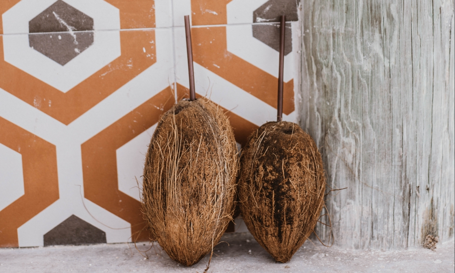 two coconuts with straws in them