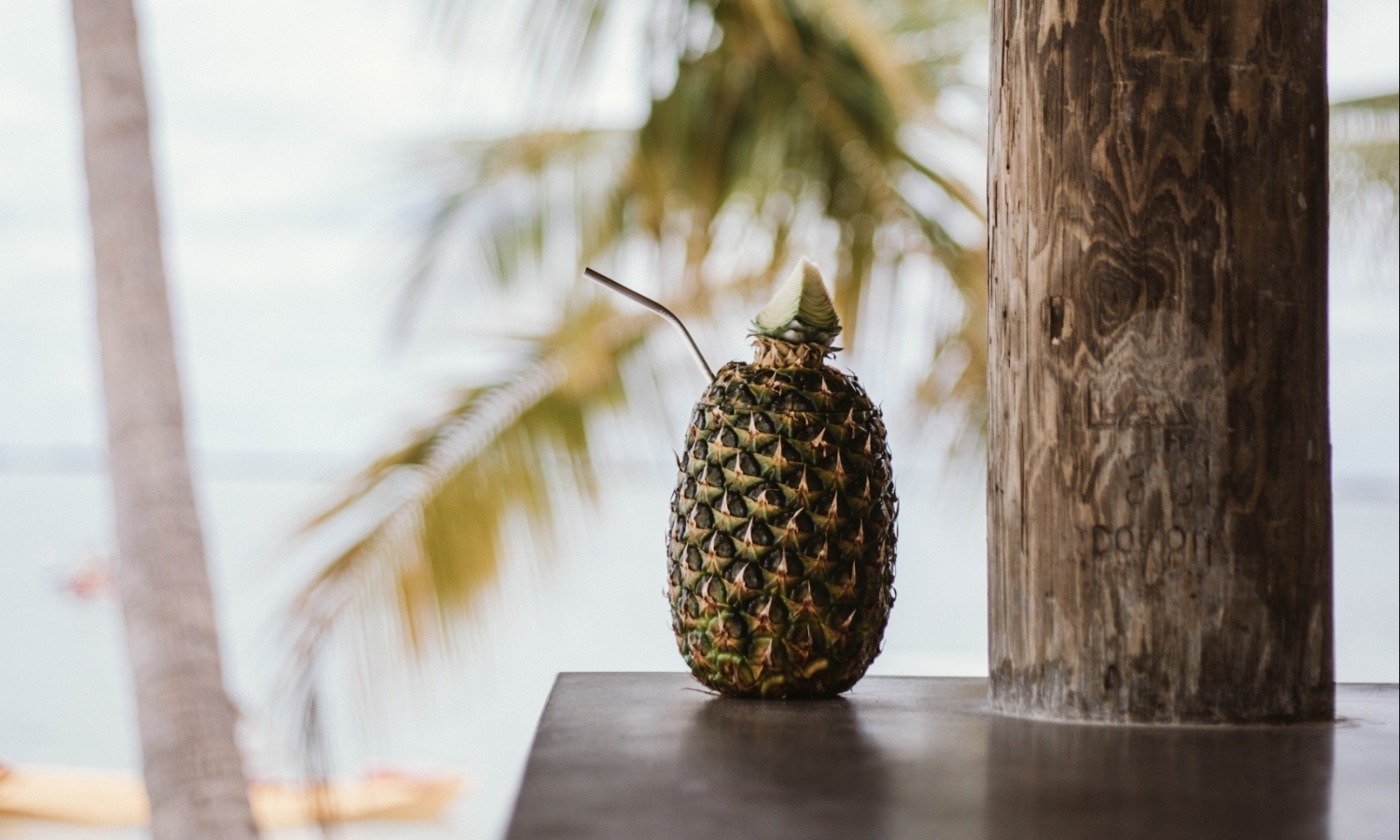 pineapple on a table with a straw