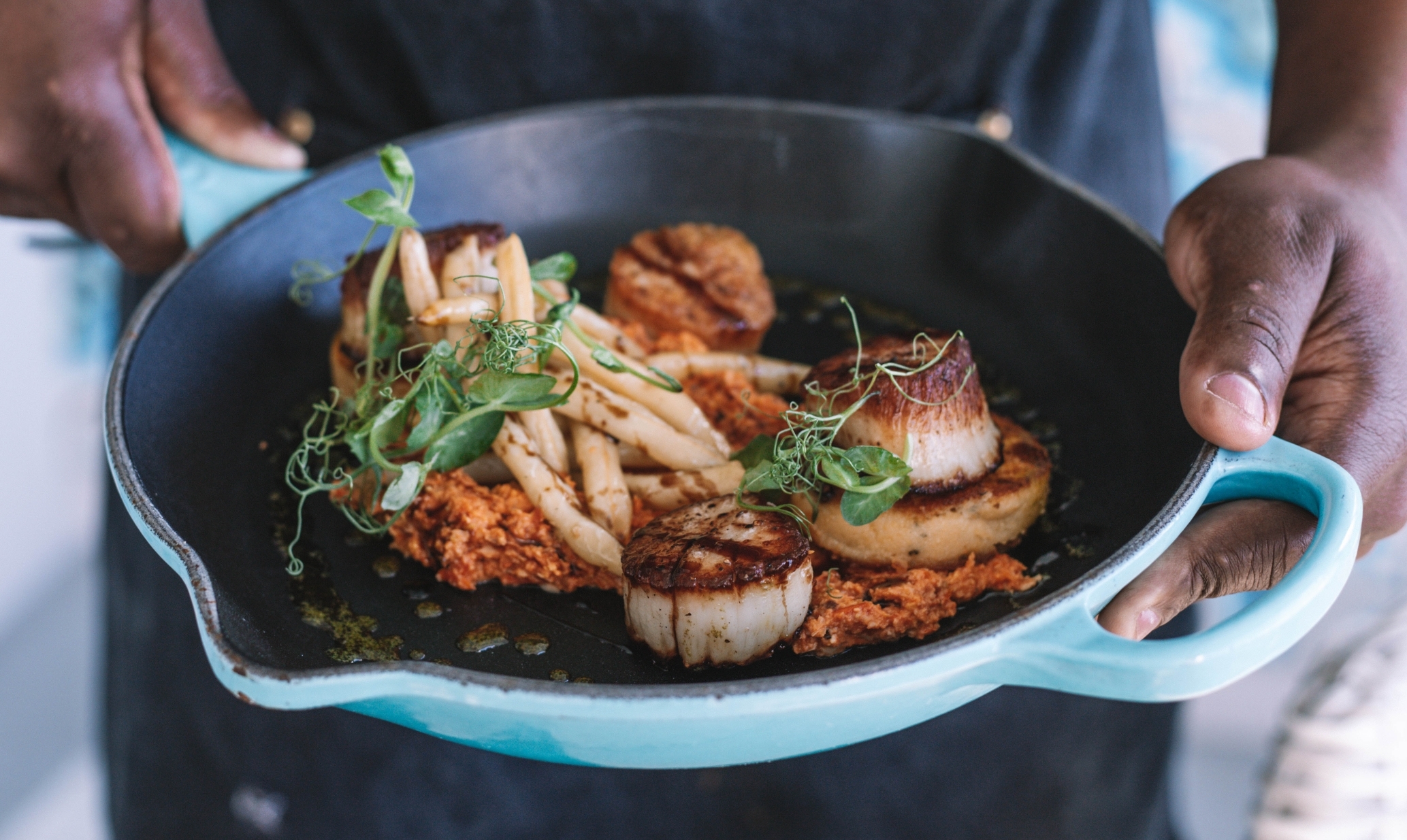 chef holding a dish in a pan
