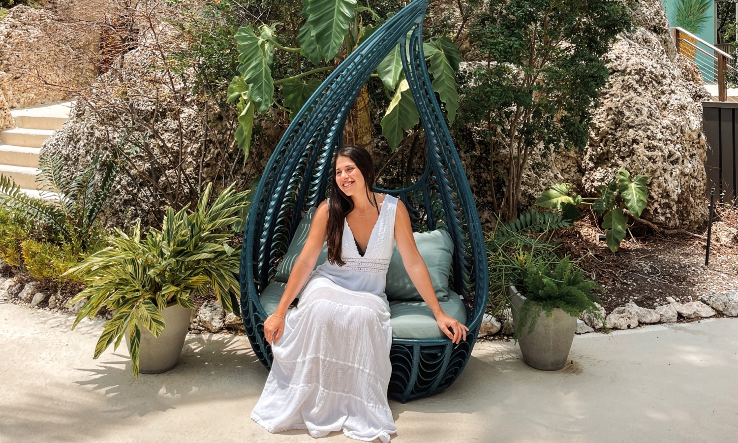 a woman in a white dress sitting outside