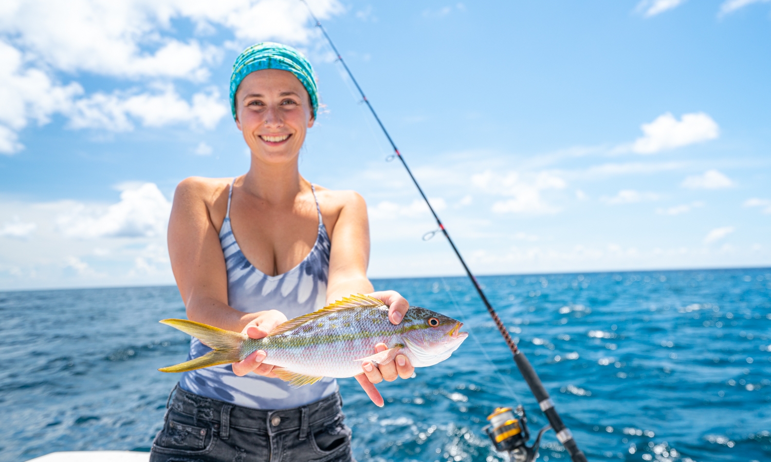 a woman holding a fish on a boat