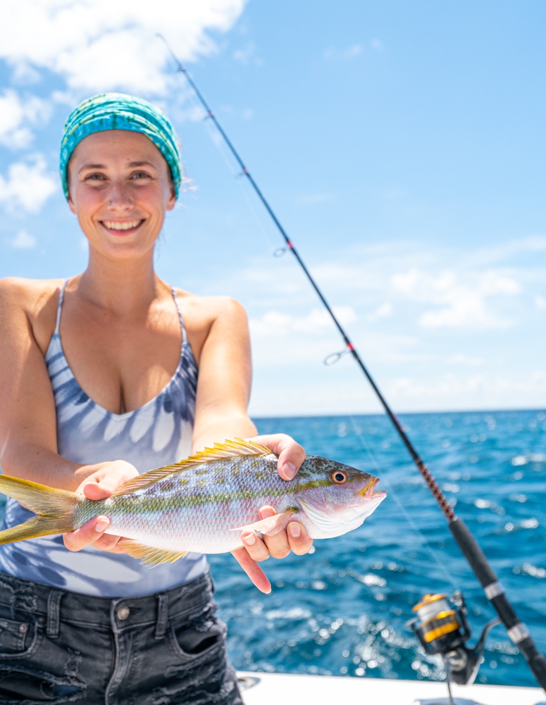 a woman holding a fish on a boat