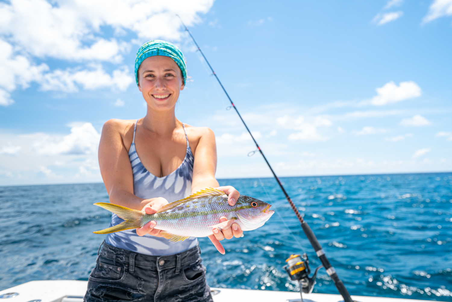 a woman holding a fish on a boat